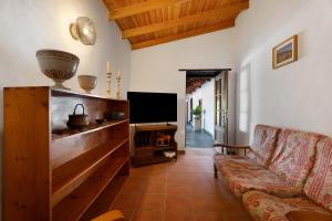 a living room with a couch and a flat screen tv at Casa Fagundo 84 in Alajeró