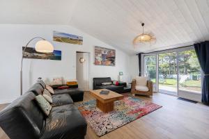 a living room with a leather couch and a table at Ile de Noirmoutier - Maison T4 in La Guérinière