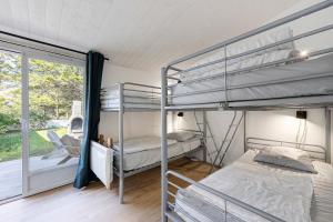 a bedroom with two bunk beds and a window at Ile de Noirmoutier - Maison T4 in La Guérinière
