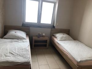 two beds in a room with a window at Fewo Stremme in Altenlotheim +2 photos