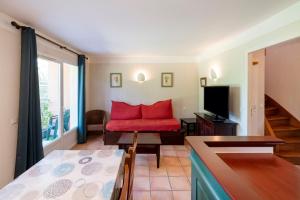a living room with a red chair and a television at Domaine de Pinsolle in Soustons +75 photos