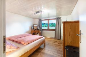 a bedroom with a bed and a window at Ferienwohnung Käppeleblick in Bernau im Schwarzwald