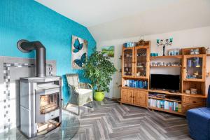 a living room with a fireplace and a tv at Ferienwohnung am Töschenbach in Hennstedt