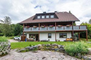 a large white house with a roof at Ferienwohnung Käppeleblick in Bernau im Schwarzwald