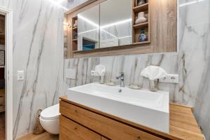 a bathroom with a white sink and a toilet at Ferienwohnung Schluchsee Idylle in Schluchsee +12 photos