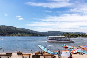 a large boat on a lake with tables and benches at Ferienwohnung Schluchsee Idylle in Schluchsee