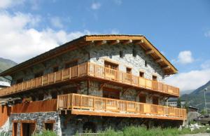 a building with wooden balconies on the side of it at Chalet Les Liouès in Sollières-Sardières