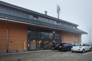a building with two cars parked in a parking lot at Haus Wiesenquelle in Feldberg