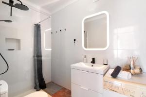 a white bathroom with a sink and a shower at A Casa de Emy in Cabanas de Tavira +13 photos