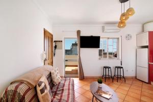 a living room with a couch and a table at A Casa de Emy in Cabanas de Tavira