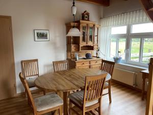 a dining room with a wooden table and chairs at Uhlenhoff Boyken in Bokellerostermoor