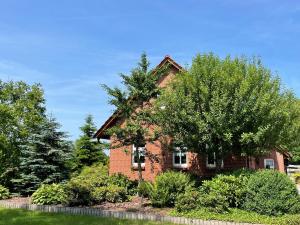 an old brick house with trees in front of it at Uhlenhoff Boyken in Bokellerostermoor