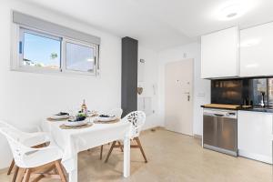 a white dining room with a white table and chairs at Sungolfbeach El Girasol in Orihuela
