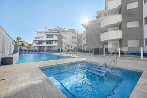 a swimming pool in front of some apartment buildings at Sungolfbeach El Girasol in Orihuela