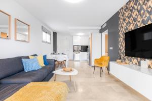 a living room with a couch and a tv at Sungolfbeach El Girasol in Orihuela