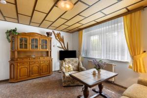 a living room with a wooden cabinet and a table at Ferienwohnung am Bloschk in Schwielochsee