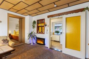 a living room with a yellow wall and a fireplace at Ferienwohnung am Bloschk in Schwielochsee