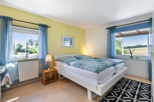 a bedroom with a bed and two windows at Ferienwohnung Devich in Oersberg