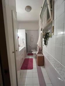 a white bathroom with a toilet and a sink at Casa Fiore in Borgo Capanne +13 photos
