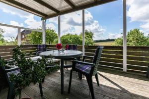a patio with a table and chairs on a deck at Ferienwohnung Devich in Oersberg