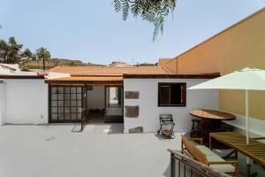 an outdoor patio with a table and an umbrella at Casa Fagundo 84 in Alajeró