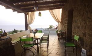 a dining room with a table and chairs on a patio at Antico Dammuso Al Tramonto in Pantelleria