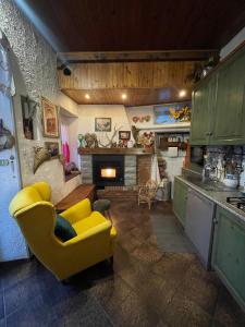 a kitchen with a yellow couch and a fireplace at Casa Fiore in Borgo Capanne