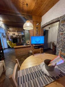 a living room with a table and a tv at Casa Fiore in Borgo Capanne