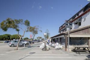 a group of people sitting in chairs on a street at Hostal Avenida in Conil de la Frontera