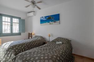 a bedroom with two beds and a bedskirts at Plaza Cadiz 4 overlooking Playazo in Nerja