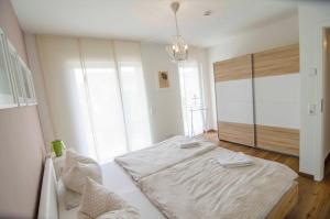 a bedroom with a bed and a chandelier at Bianca's Kaiserstuhl in Ihringen