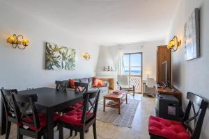 a dining room and living room with a table and chairs at Plaza Cadiz 4 overlooking Playazo in Nerja