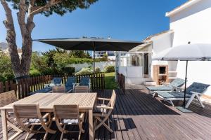 a patio with a wooden table and chairs and an umbrella at Superbly situated villa 67 in Mijas Costa