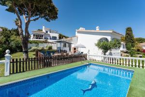 a villa with a swimming pool in front of a house at Superbly situated villa 67 in Mijas Costa
