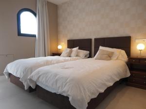 a bedroom with two beds with white sheets and a window at El Cafetal de Veronica in Marbella