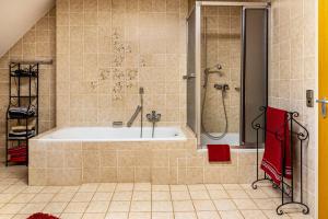 a bathroom with a tub and a shower at Altes Pfarrhaus in Vöhrenbach +35 photos