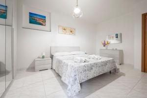 a white bedroom with a bed and a table at Casa di Titina a Otranto in Otranto