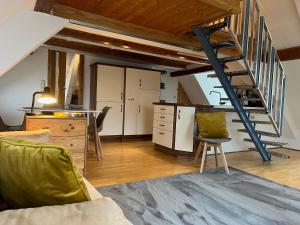 a kitchen and living room with a staircase in a loft at Galeriewohnung mit Seeblick in Absberg