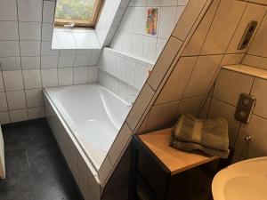 a small bathroom with a tub and a sink at Galeriewohnung mit Seeblick in Absberg
