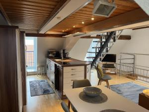 a kitchen with a staircase and a table in a room at Galeriewohnung mit Seeblick in Absberg +8 photos