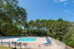 a large swimming pool with chairs and people in it at Domaine de Pinsolle in Soustons