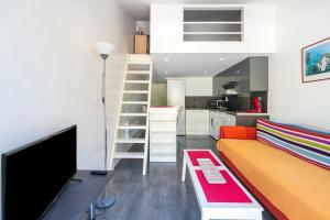 a living room with a couch and a television at Appartement de charme - spa privé in Biarritz