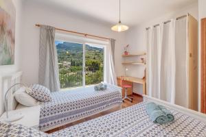 a bedroom with two beds and a large window at Casa Caterina in Port de Soller +25 photos