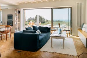 a living room with a blue couch and a table at La Perle in Plobannalec-Lesconil