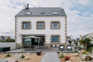a house with a deck and a patio at La Perle in Plobannalec-Lesconil
