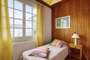 a small bedroom with a bed and a window at Maison Am Stram Gram in La Tranche-sur-Mer