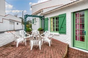 a group of white chairs sitting on a patio at Maison Am Stram Gram in La Tranche-sur-Mer