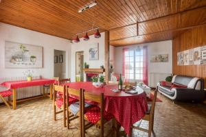 a living room with a red table and chairs at Maison Am Stram Gram in La Tranche-sur-Mer