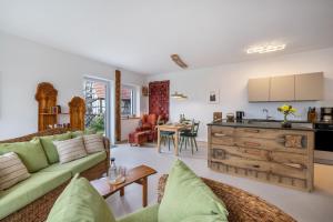 a living room with a couch and a kitchen at Alb-Sonne Ferienwohnung in Sonnenbühl