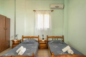two twin beds in a room with a window at Vangelis studio 1 in Kefalonia